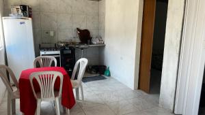 a kitchen with a table and chairs and a refrigerator at Prive Dona Valentina in Itamaracá