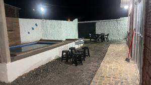 a swimming pool with stools and a table and chairs at Prive Dona Valentina in Itamaracá