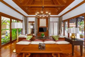 a living room with a large couch and a chandelier at Royal Legacy Golf Private Villa in Rawai Beach