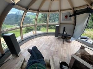a person laying on the floor of a round room with a view at A charming alpine chalet in Ensex