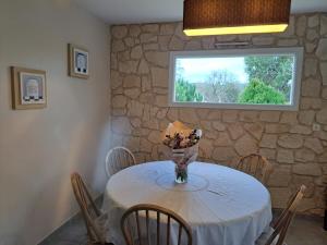 a dining room with a table with a vase of flowers at La Tropézienne in Castéra-Verduzan