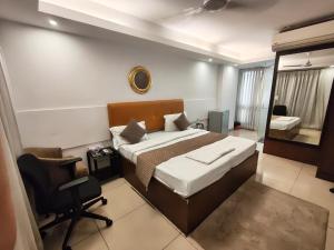 a bedroom with a bed and a desk and a chair at Blueberry Residency - Hauz khas fort in New Delhi