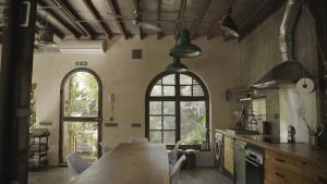 a kitchen with a table and a large window at Retiro Park Industrial House in Madrid