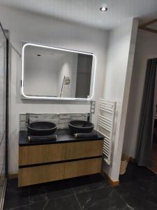 a bathroom with two sinks on a counter with a mirror at Ô Chalet Normand in Colomby