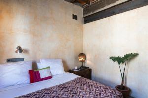 a bedroom with a bed and a plant and a lamp at Retiro Park Industrial House in Madrid