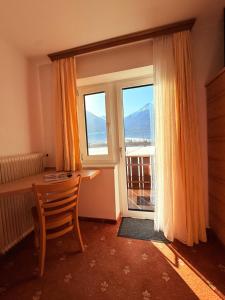 a room with a desk and a window with a view at Pension Plattenhof in Telfs