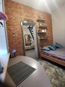 a room with a bed and a brick wall at Alejas KAMBARI in Myza Bene