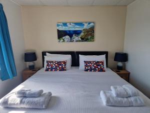 a bedroom with a bed with two towels on it at Wheal Rodney Holiday Park in Marazion +53 photos