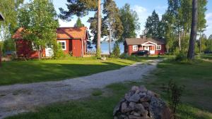 uma casa e uma casa com uma pedra no quintal em Bäcka Holiday Home em Orsa