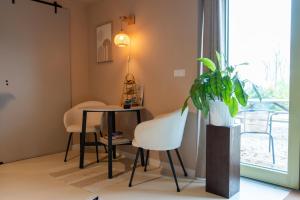 a dining room with a table and chairs and a plant at Mera Luxe Wellness B&B, Ibiza-Bohemian Style Suites, Adults Only, optioneel prive Outdoor Wellness, Massage, Vuurkorf, gratis fles Wijn of Bubbels in America