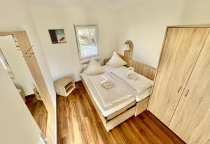 a small room with a bed and a mirror at Seepark Wolfswinkel in Storkow