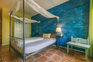 a bedroom with a bed and a blue wall at Rosi's Dorfwirtschaft in Rottenacker