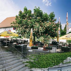 a patio with tables and chairs and umbrellas at Rosi's Dorfwirtschaft in Rottenacker