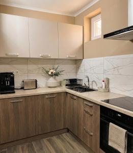 a kitchen with wooden cabinets and a sink and a microwave at Villa J'adore in Crasna