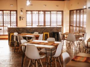 a restaurant with tables and chairs and windows at Kudu Kopje Lodge in Kroondal