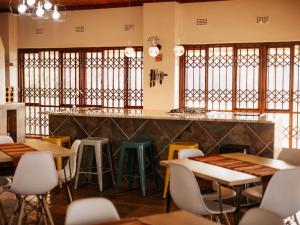 a restaurant with tables and chairs and a bar at Kudu Kopje Lodge in Kroondal