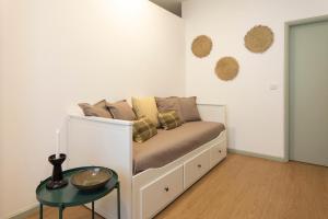 a couch with pillows on it in a room at Casa em bairro típico de Aveiro in Aveiro +3 photos