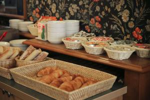 a table with baskets of bread and other foods at Hôtel du Cheval Rouge in Versailles