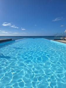 a swimming pool with the ocean in the background at T2 Apart - Beach View - Santa Maria Center in Santa Maria