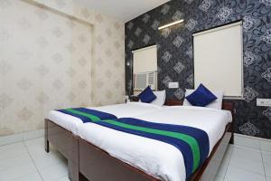 a bedroom with a large bed with blue and green stripes at Bengal Inn in Kolkata