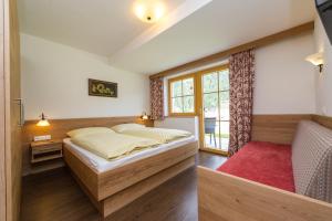 a bedroom with a large bed and a window at Haarlehenhof in Grossarl