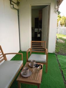 a patio with two chairs and a table with cups at Studio CARAIBE in Saint-François