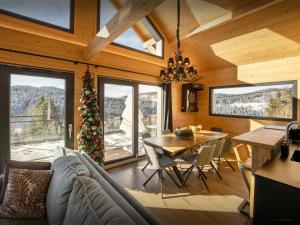 a living room with a table and a christmas tree at Chalet L'Ursus - OVO Network in Gérardmer +22 photos