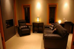 a living room with a leather couch and a chair at Shades of Jade Inn & Spa in Roberts Creek