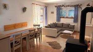 a kitchen and living room with a table and a couch at Chalupa ve Sněžném in Sněžné