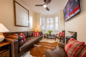 a living room with a leather couch and a flat screen tv at Trevor Street in Holywood