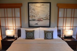 a bedroom with a large bed with two lamps at Shades of Jade Inn & Spa in Roberts Creek