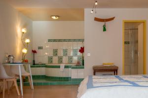 a bedroom with a bed and a bathroom with a tub at Badehotel Salina Maris – Wellness & Vintage in Mörel
