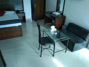 a living room with a glass table and a couch at Hotel Rose Garden in Chittagong