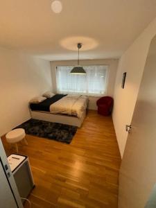 a small bedroom with a bed and a window at A room in semi shared flat in Wallisellen
