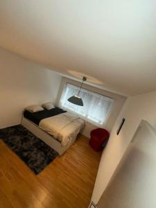 a small bedroom with a bed and a window at A room in semi shared flat in Wallisellen