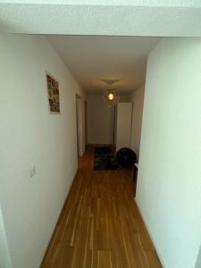 an empty hallway with a room with wood floors at A room in semi shared flat in Wallisellen