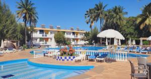 a large swimming pool with chairs and a hotel at Palma Rima Hotel in Kololi