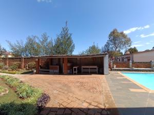 a pool house with a pavilion next to a swimming pool at GARDEN HOLiDAY in Antsirabe