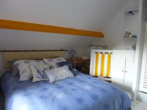 a bedroom with a blue bed with pillows on it at La Boulangerie in Genêts