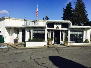 Um edifício branco com uma bandeira americana à frente. em Flagship Inn em Bremerton