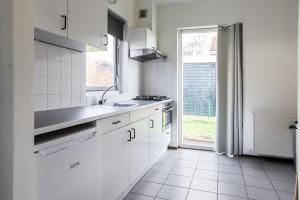 a white kitchen with a sink and a window at Zilt vakantiehuisje - Rekerlanden 283 in Schoorldam