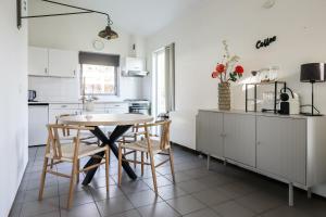 a kitchen with white cabinets and a table and chairs at Zilt vakantiehuisje - Rekerlanden 283 in Schoorldam
