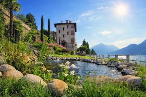 a building on a hill next to a body of water at Villa Marina - Como lake in Bellano