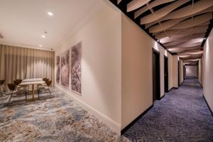a hallway with a table and chairs and paintings on the wall at ASA Molina Plaza in Molina de Segura +29 photos