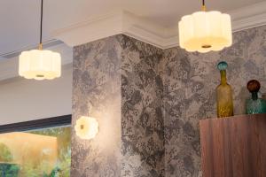a room with two chandeliers and a wine bottle on a shelf at ASA Molina Plaza in Molina de Segura