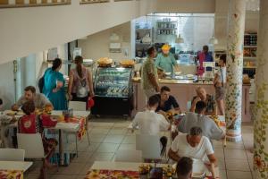 a group of people sitting at tables in a restaurant at Elephant guesthouse in Somogyvámos +29 photos
