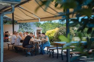 a group of people sitting at tables in an outdoor restaurant at Elephant guesthouse in Somogyvámos