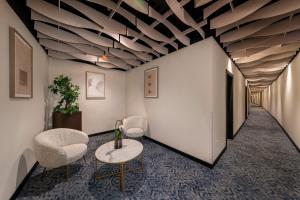 a hallway with chairs and a table and a ceiling at ASA Molina Plaza in Molina de Segura