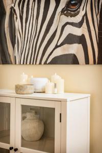 a table with candles and a zebra painting on the wall at Trevor Street in Holywood