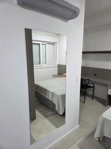 a mirror in a white room with a bed at LOFT1304 Maxplaza Canoas in Canoas +12 photos
